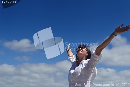 Image of happy young woman with spreading arms to sky