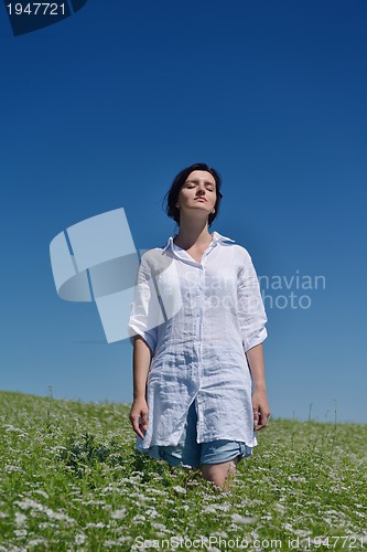 Image of Young happy woman in green field