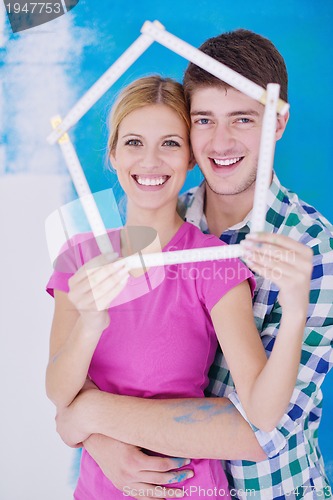 Image of happy couple paint wall at new home