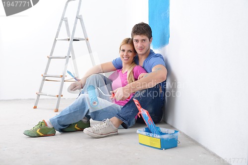 Image of happy young cople relaxing after painting in new home