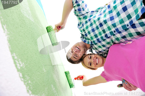 Image of happy couple paint wall at new home