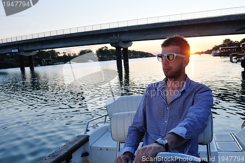 Image of portrait of happy young man on boat