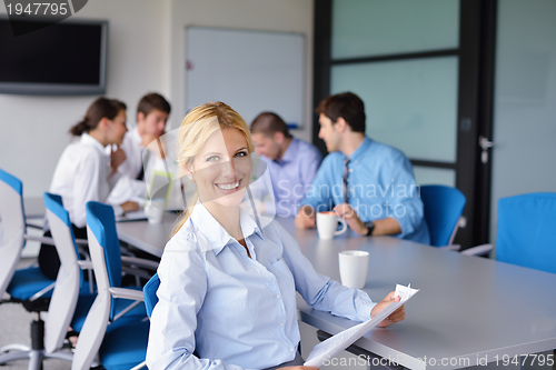Image of business woman with her staff in background at office