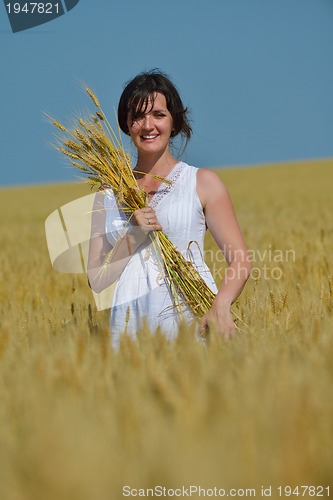 Image of young woman in wheat field at summer
