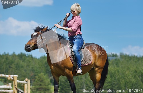 Image of happy woman  on  horse