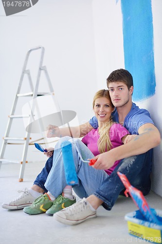 Image of happy young cople relaxing after painting in new home