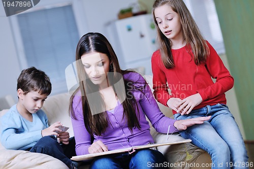 Image of young mom play with their kids at home and reading book