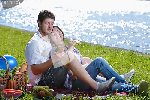 Image of happy young couple having a picnic outdoor