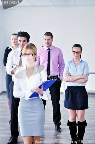 Image of business woman standing with her staff in background
