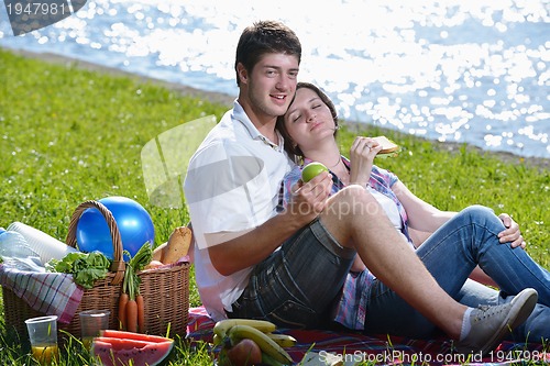 Image of happy young couple having a picnic outdoor