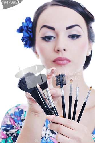 Image of beautiful young woman applying makeup