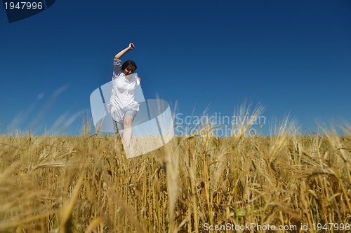 Image of young woman in wheat field at summer