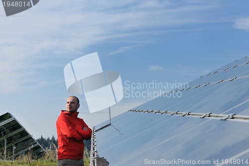 Image of engineer using laptop at solar panels plant field