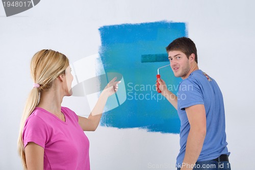 Image of happy couple paint wall at new home