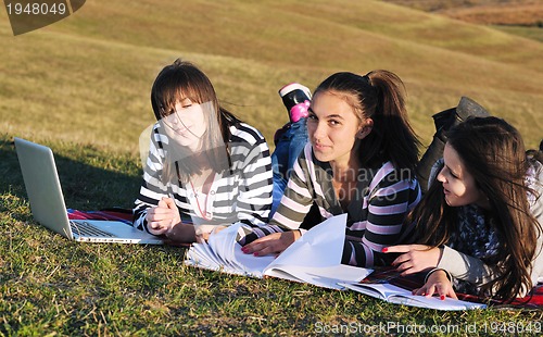 Image of group of teens working on laptop outdoor