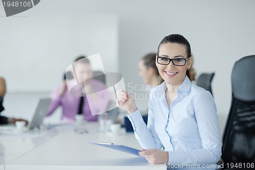 Image of business woman standing with her staff in background