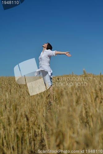 Image of young woman in wheat field at summer