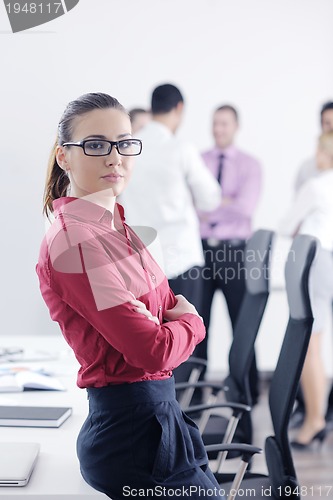 Image of business woman standing with her staff in background