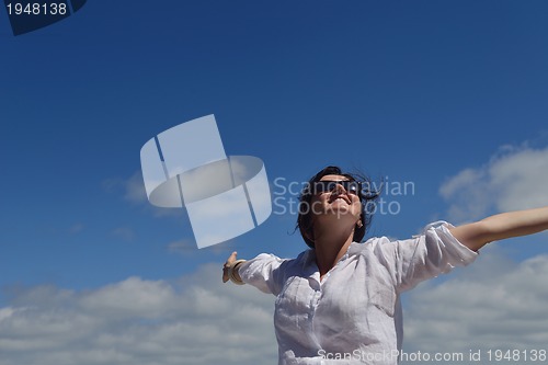 Image of happy young woman with spreading arms to sky