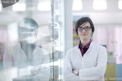 Image of pharmacist chemist woman standing in pharmacy drugstore