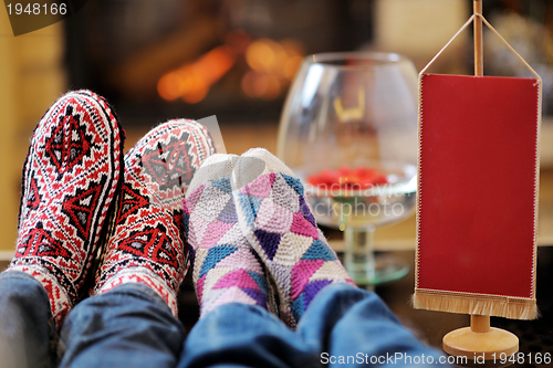 Image of Young romantic couple relax on sofa in front of fireplace at hom