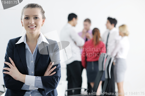 Image of business woman standing with her staff in background