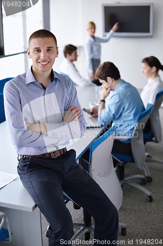 Image of business man  on a meeting in offce with colleagues in backgroun