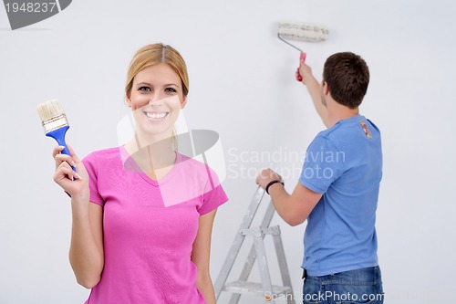 Image of happy couple paint wall at new home