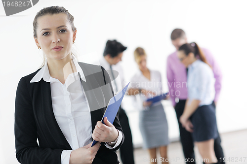 Image of business woman standing with her staff in background