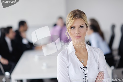 Image of business woman standing with her staff in background