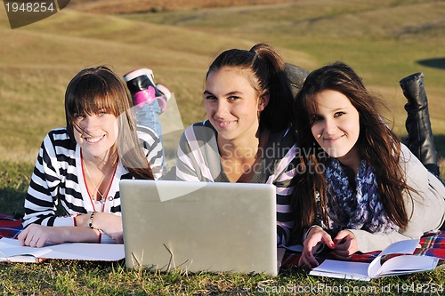 Image of group of teens working on laptop outdoor
