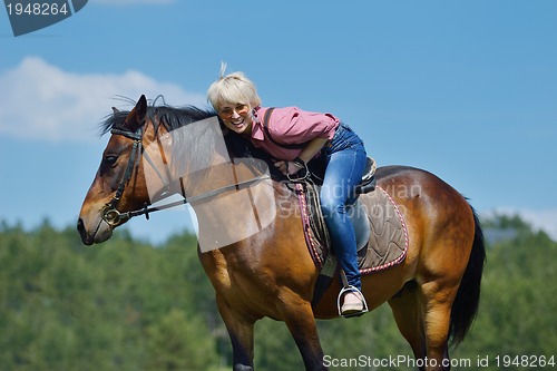 Image of happy woman  on  horse