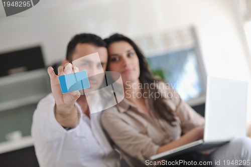 Image of joyful couple relax and work on laptop computer at modern home
