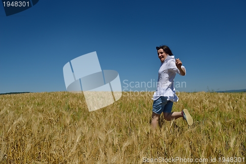 Image of young woman in wheat field at summer