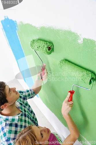 Image of happy couple paint wall at new home