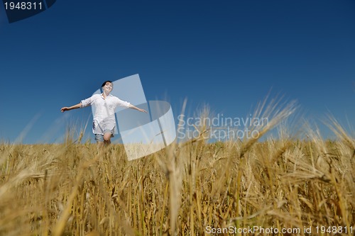 Image of young woman in wheat field at summer