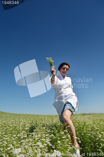 Image of Young happy woman in green field