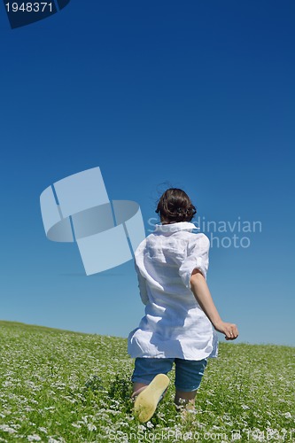 Image of Young happy woman in green field