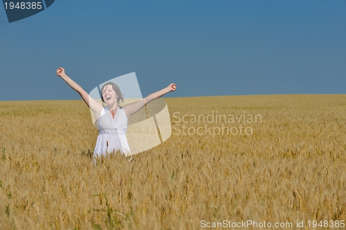 Image of young woman in wheat field at summer