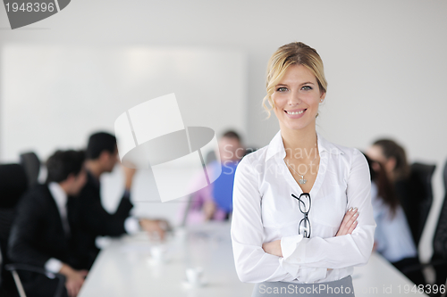 Image of business woman standing with her staff in background