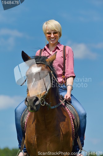 Image of happy woman  on  horse