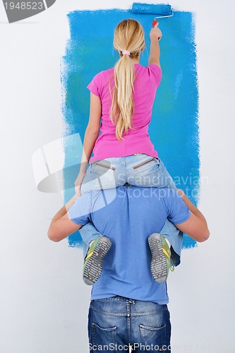 Image of happy couple paint wall at new home