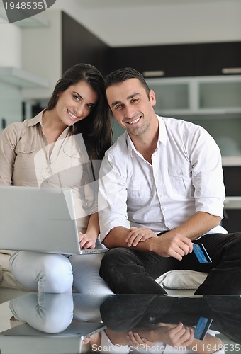 Image of joyful couple relax and work on laptop computer at modern home