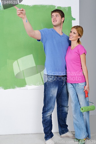 Image of happy couple paint wall at new home