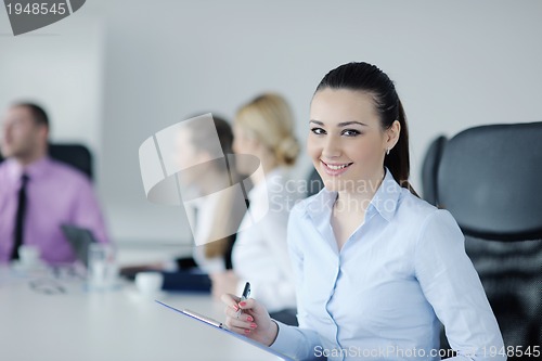 Image of business woman standing with her staff in background