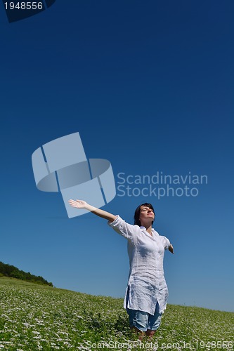 Image of Young happy woman in green field