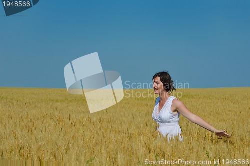 Image of young woman in wheat field at summer