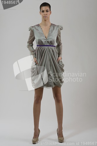 Image of elegant woman in fashionable dress posing in the studio