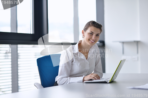 Image of Young pretty business woman with notebook in the office