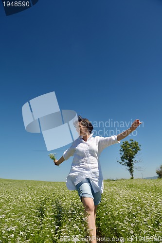 Image of Young happy woman in green field